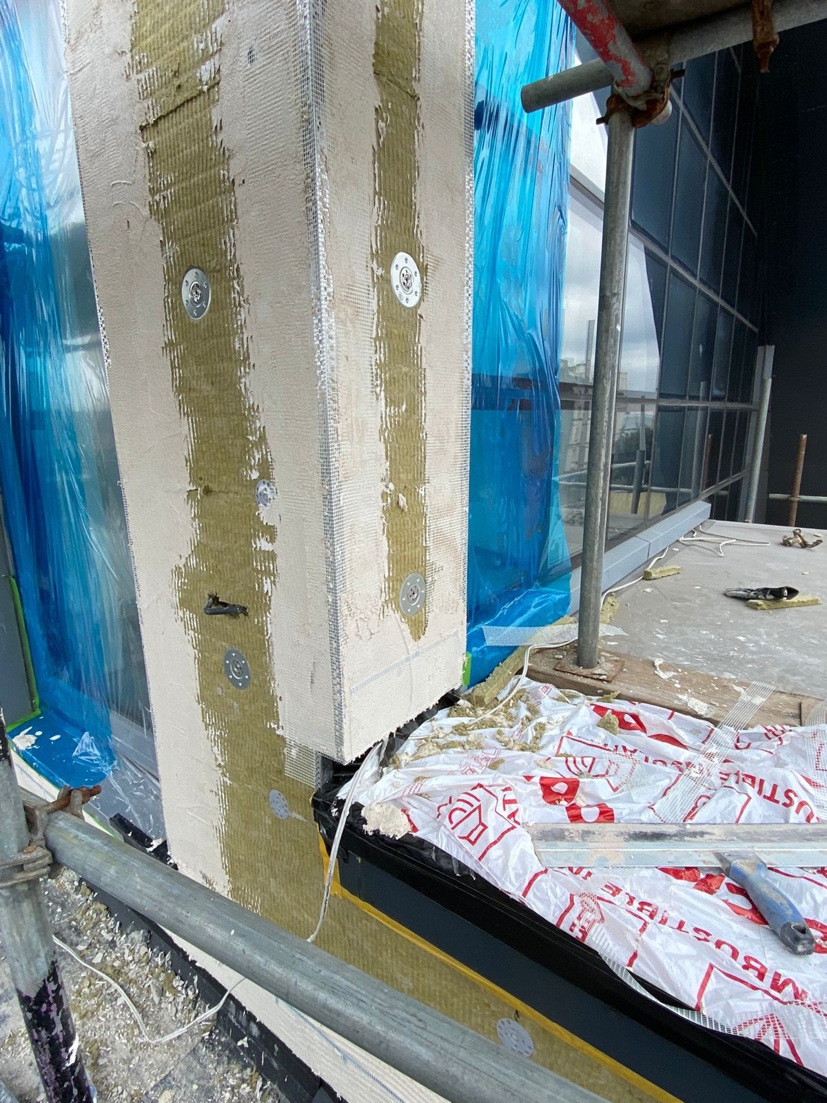 New mineral wool insulation and rendered façade build-up being installed