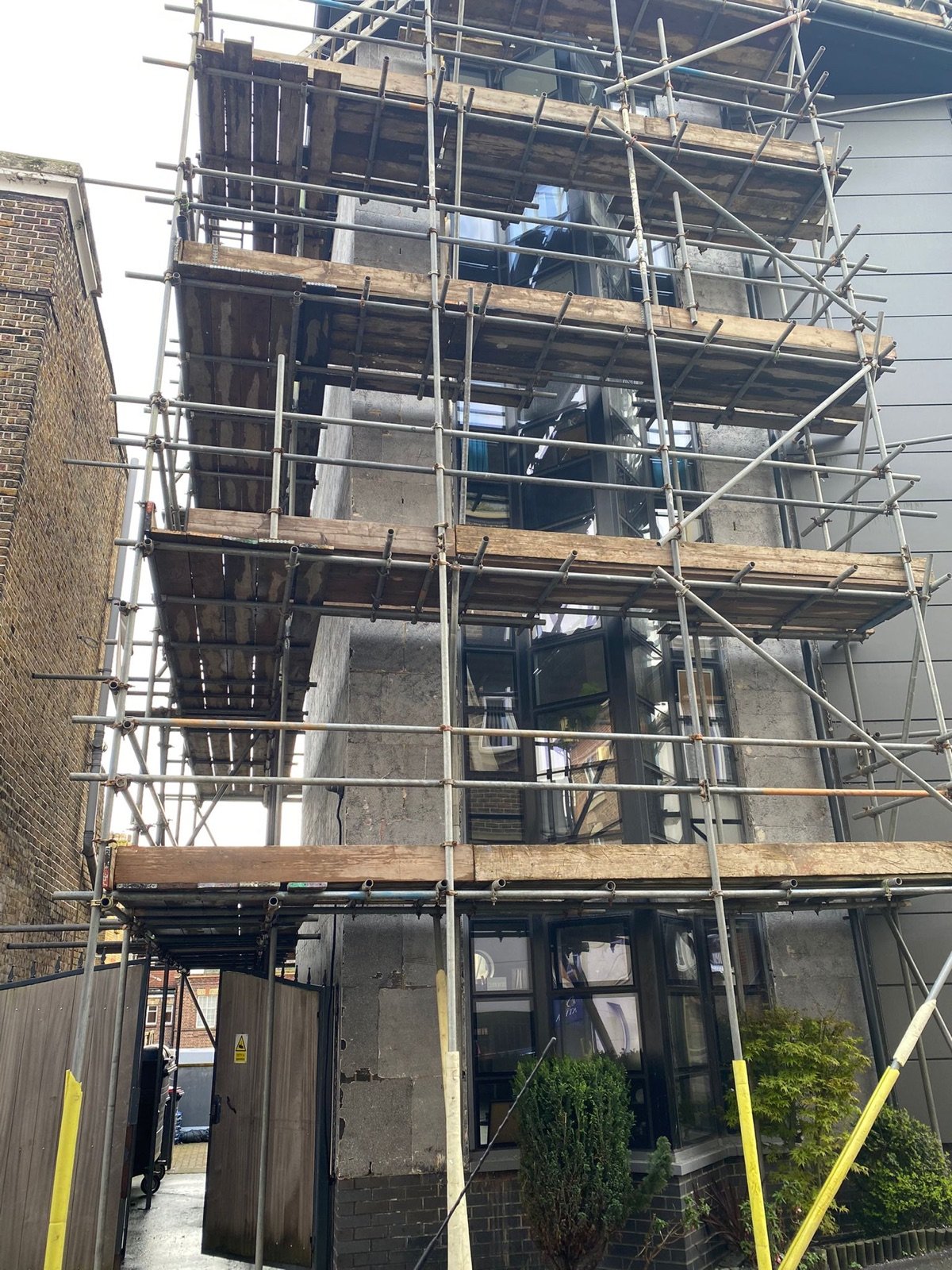Liberty Court with the original façade materials stripped back behind scaffolding